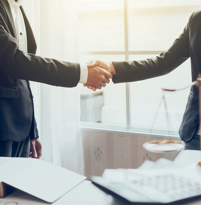 Two people shaking hands in a law office